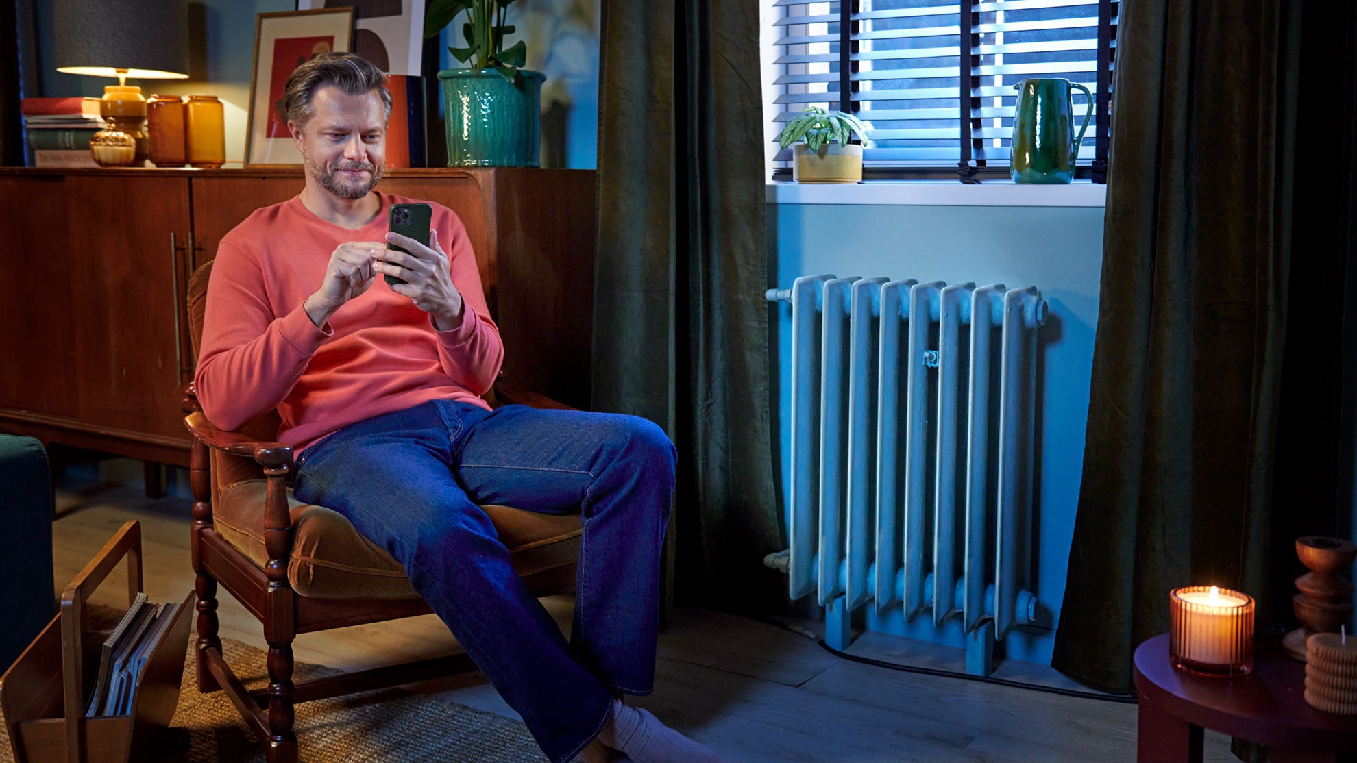 Egy férfi az Onecta alkalmazással szabályozza levegő-víz hőszivattyúját