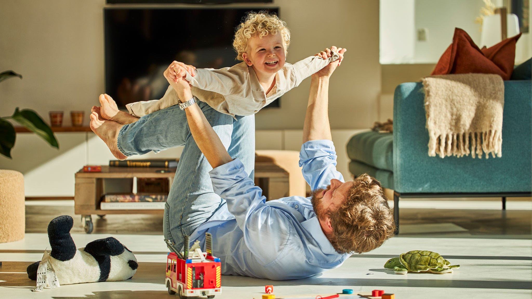 Apa és fia boldogan játszanak együtt és élvezik a padlófűtés melegét