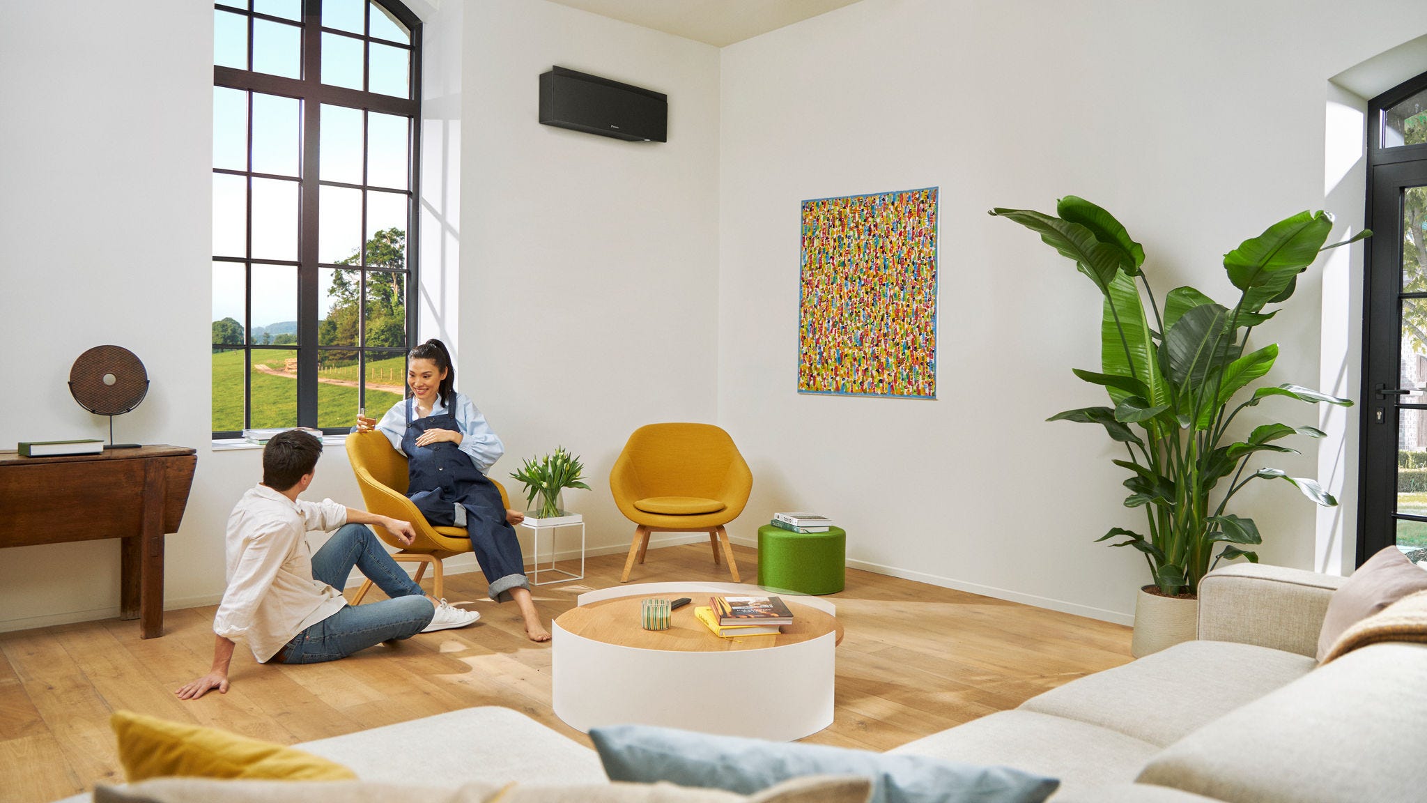 Gyermeket váró pár beszélget, miközben a nő a széken ül