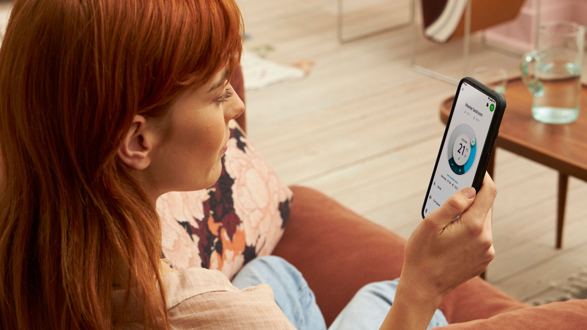 Egy nő az Onecta alkalmazást használja a fűtés ellenőrzéséhez