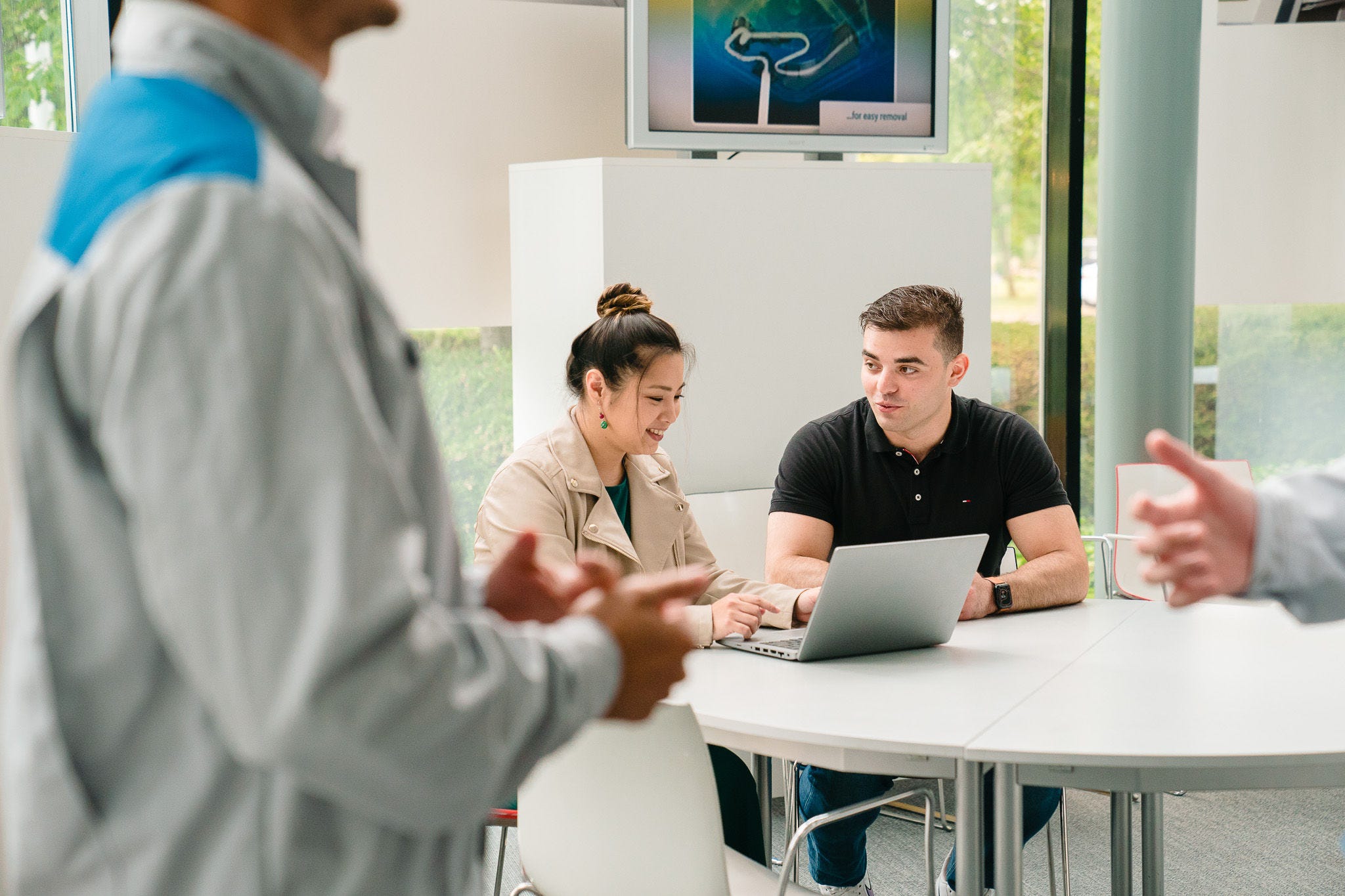 Egy nő valamit magyaráz a laptopján egy férfinak