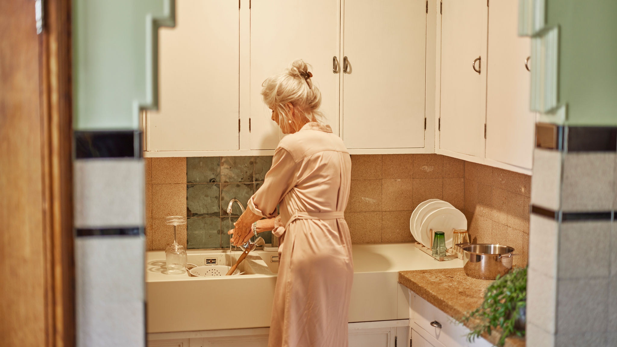 Nő edényeket mosogat a Multi Split rendszerrel melegített vízzel