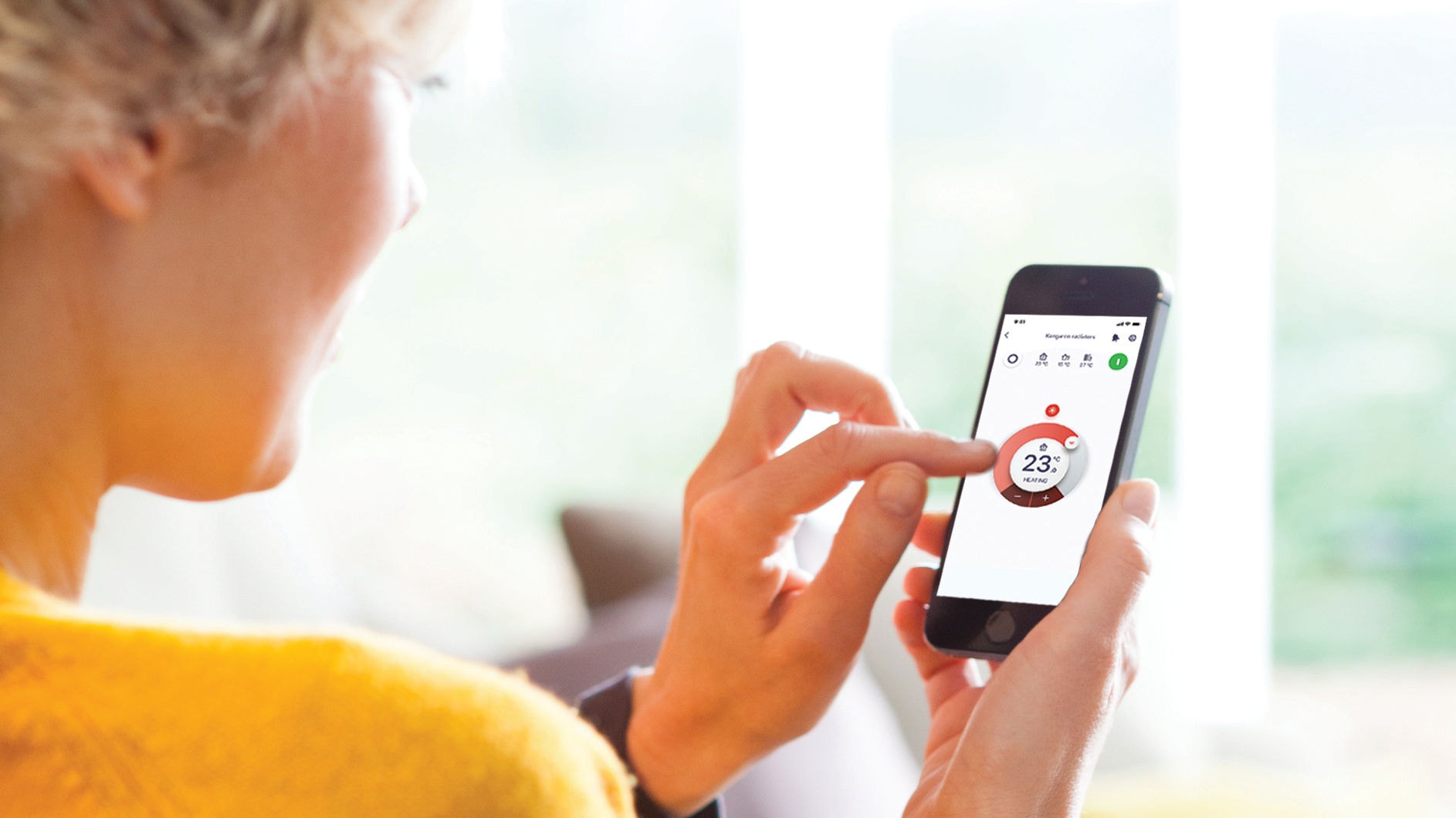 Egy nő használja az Onecta alkalmazást az otthona fűtése, hűtése és használati meleg vize szabályozására