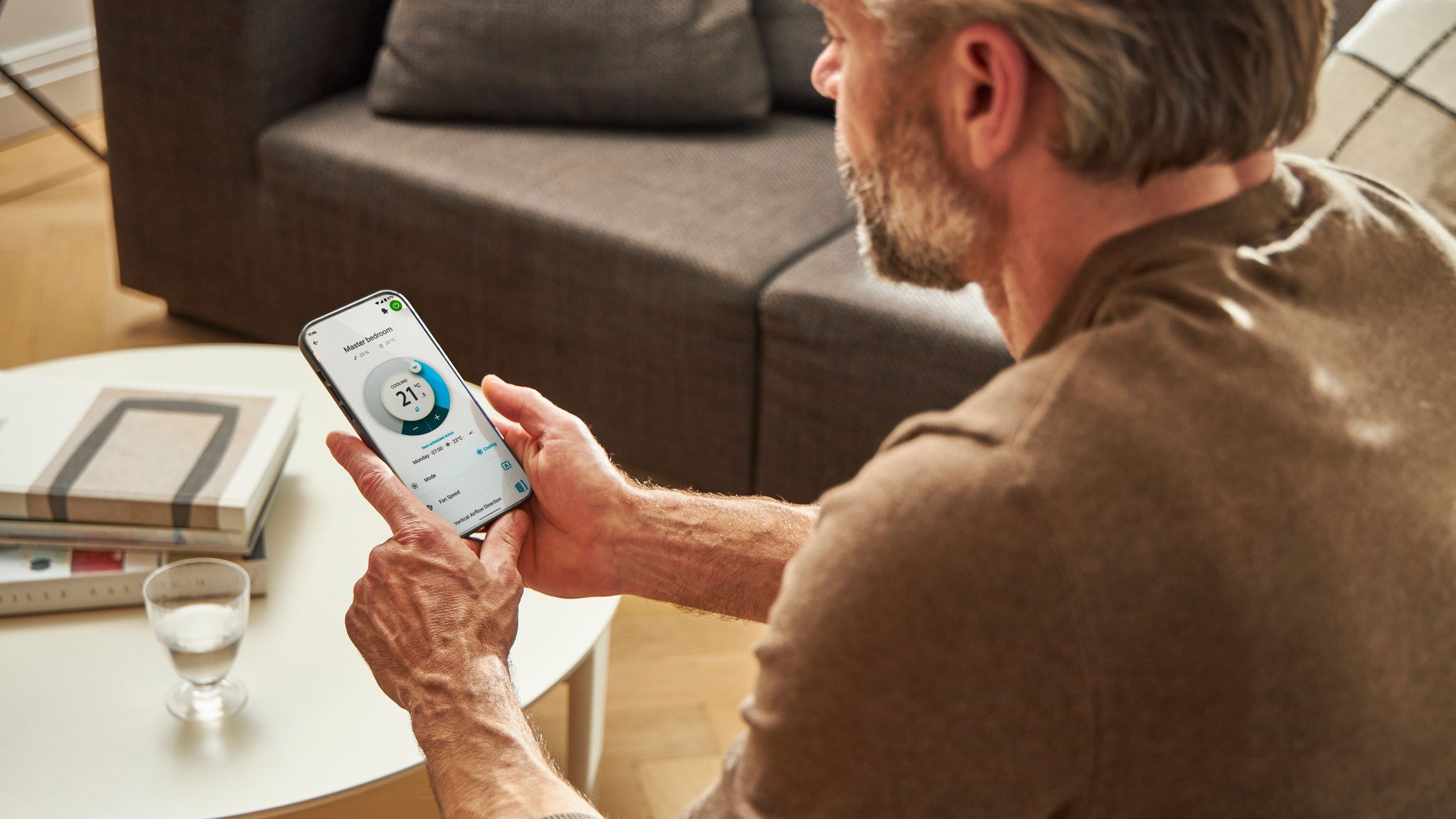 Egy férfi az alkalmazással szabályozza a fűtést