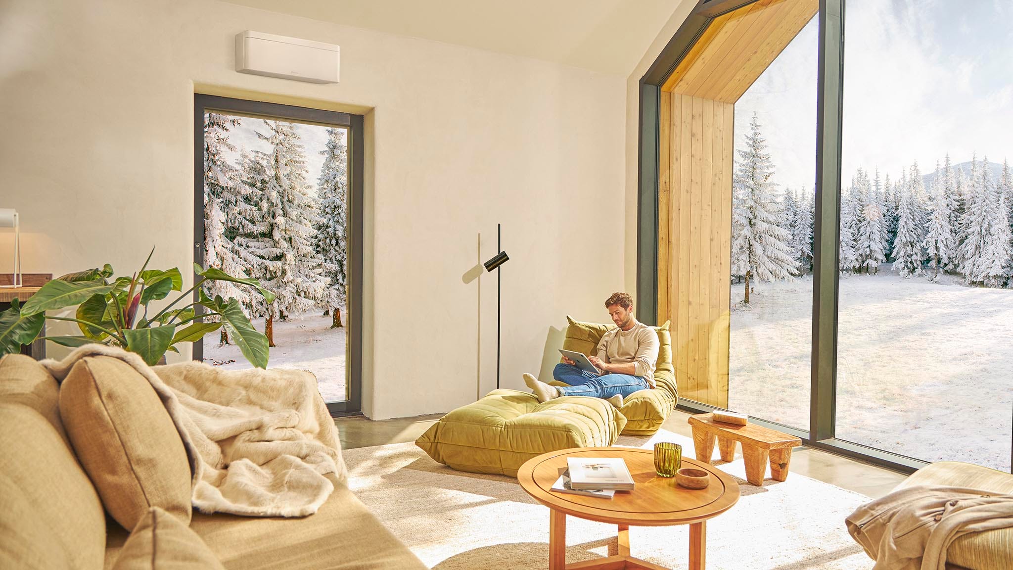 Férfi egy kanapén ül és élvezi a klíma általi fűtést