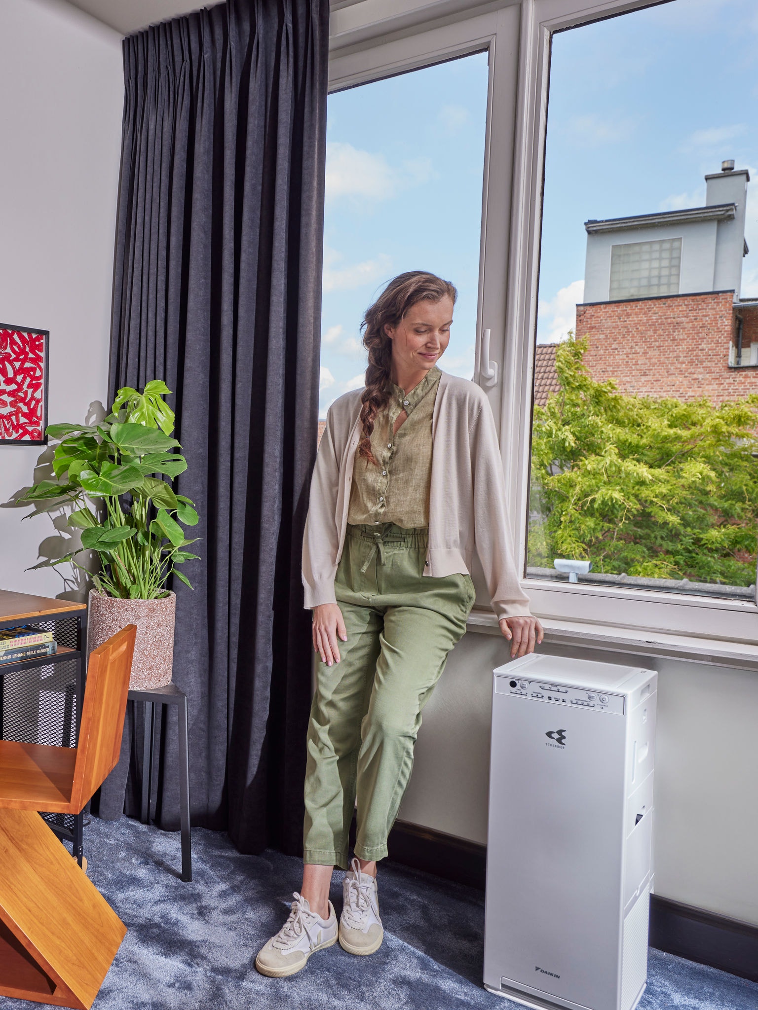 Nő áll a légtisztítója mellett